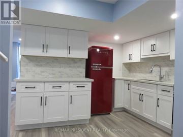 Brampton (Fletcher's West) apartment for rent - A kitchen with white cabinets and a red fridge.
