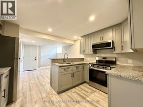 St. Catharines (Secord Woods) apartment for rent - A kitchen with a refrigerator, sink, oven, and microwave.