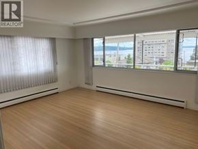 West Vancouver apartment for rent - A room with wooden flooring and a window overlooking a cityscape.