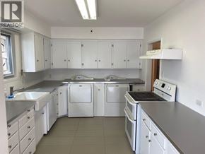 West Vancouver apartment for rent - A white kitchen with a stove, sink, and cabinets.