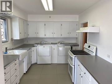 West Vancouver apartment for rent - A white kitchen with a stove, sink, and cabinets.