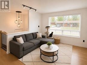 Petawawa apartment for rent - A living room with a grey couch, a white coffee table, and a window with a view of a building.
