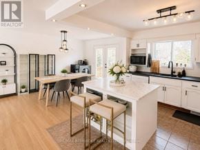 Petawawa apartment for rent - A kitchen with a white island and a dining table with chairs.