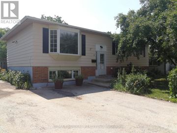Oakville (Cp College Park) apartment for rent - A small house with a white door and windows is surrounded by greenery.