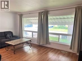 Waterloo apartment for rent - A living room with a grey couch, a coffee table, and a window with curtains.