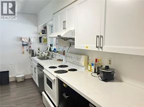 Waterloo apartment for rent - A white kitchen with a stove top oven and a black pot on the stove.