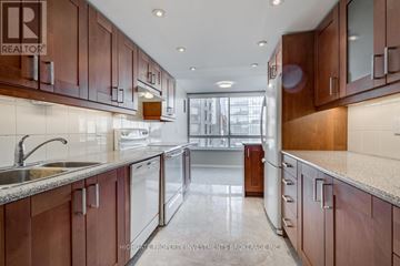 Toronto (Kensington-Chinatown) condo for rent - A kitchen with brown cabinets and a sink.