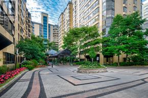 Toronto (Kensington-Chinatown) condo for rent - A courtyard with a fountain surrounded by trees and buildings.