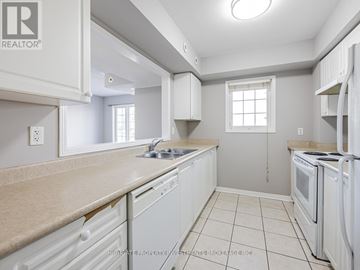 Toronto (Rouge) townhouse for rent - A kitchen with white cabinets and appliances.