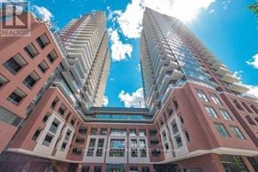 Toronto (Humber Heights) condo for rent - A tall pink building with a glass balcony on the top floor.