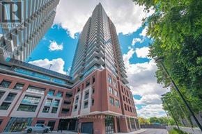 Toronto (Humber Heights) condo for rent - A tall building with a red brick facade and a white tower with a pointed top is surrounded by trees and has a sign that reads "HOMELIFE MIRACLE REALITY".