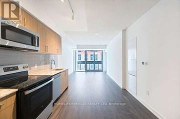 Toronto (Humber Heights) condo for rent - A kitchen with wooden cabinets and black appliances.