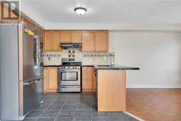 Markham (Village Green-South Unionville) apartment for rent - A kitchen with wooden cabinets and a black countertop.