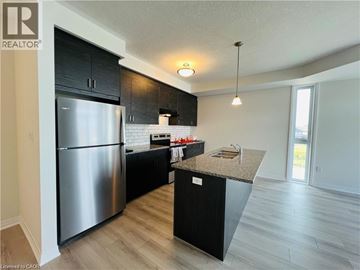 Waterloo townhouse for rent - A modern kitchen with a stainless steel refrigerator and black cabinets.