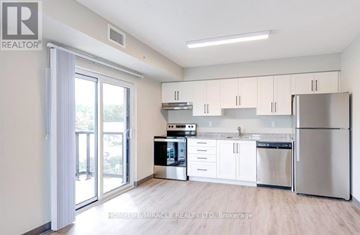 Kitchener multi-family for rent - A kitchen with white cabinets and stainless steel appliances.