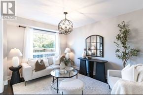 Whitby (Pringle Creek) apartment for rent - A living room with a white couch, a glass table, and a chandelier.