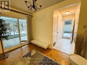 Markham (Royal Orchard) apartment for rent - A room with a chandelier, a bench, and a door leading outside.