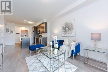 Milton (Fo Ford) condo for rent - A modern living room with a glass coffee table and a blue sofa.