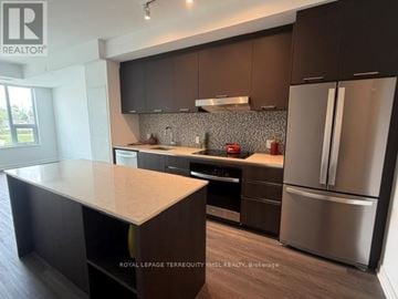 Vaughan (Uplands) condo for rent - A kitchen with dark brown cabinets and stainless steel appliances.