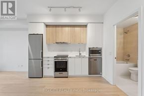 Vaughan (Brownridge) condo for rent - A modern kitchen with a refrigerator, oven, and microwave.