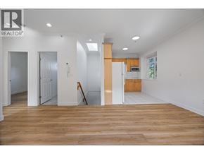 Vancouver apartment for rent - A realtor logo is on the wall of a white room.