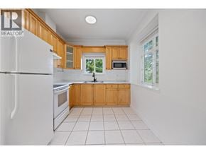 Vancouver apartment for rent - A kitchen with white appliances and wooden cabinets.