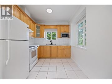 Vancouver apartment for rent - A kitchen with white appliances and wooden cabinets.