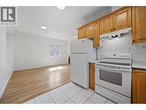 Vancouver apartment for rent - A kitchen with white appliances and wooden cabinets.