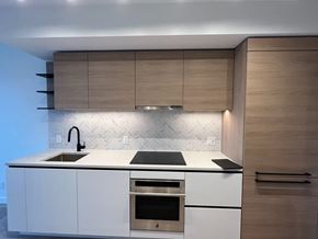 Surrey apartment for rent - A modern kitchen with a white countertop and wooden cabinets.