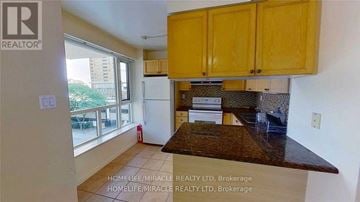 Toronto (Bay Street Corridor) condo for rent - A kitchen with wooden cabinets and a brown countertop.