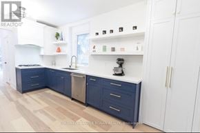 New Tecumseth (Tottenham) apartment for rent - A kitchen with white cabinets and a blue island.