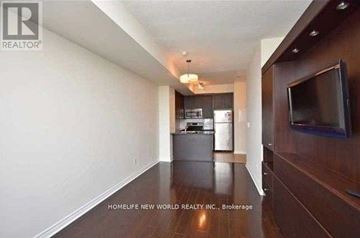 Mississauga (City Centre) condo for rent - A living room with a television and a kitchen in the background.