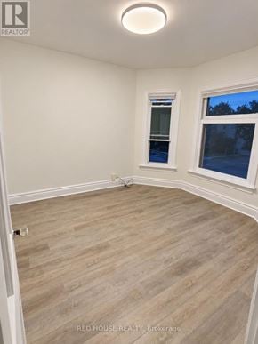 Guelph (Exhibition Park) fourplex for rent - A room with a window and a wooden floor.