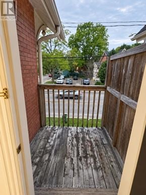 Guelph (Exhibition Park) fourplex for rent - A wooden deck with a white door and a view of the street.
