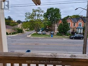Guelph (Exhibition Park) fourplex for rent - A view of a street from a balcony with a sign that says Red House Realty, Brokerage.