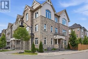 Hamilton (Waterdown) townhouse for rent - A large, multi-story residential building with a stone facade and multiple windows.