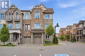 Hamilton (Waterdown) townhouse for rent - A large, multi-story residential building with a balcony on the second floor.