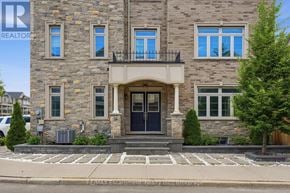 Hamilton (Waterdown) townhouse for rent - A stone building with a black door and windows.