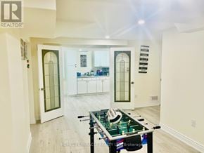 Mississauga (Meadowvale) apartment for rent - A foosball table sits in the middle of a well-lit room with white walls and a wooden floor.
