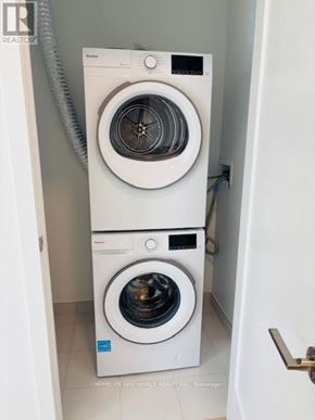 Markham (Greensborough) condo for rent - A white front load washing machine in a small laundry room.