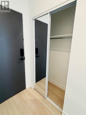 Markham (Greensborough) condo for rent - A black door with a handle is open to a white interior.