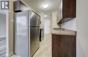 London apartment for rent - A kitchen with a refrigerator, cabinets, and a counter.