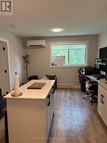 London South (South J) multi-family for rent - A kitchen with a white counter and a window with greenery outside.