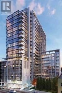 Toronto (Moss Park) condo for rent - A modern multi-story building with a glass facade is depicted in the image.