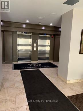 Guelph (Downtown) condo for rent - A hallway with a black doormat that says Planet Realty Inc. Brokerage.