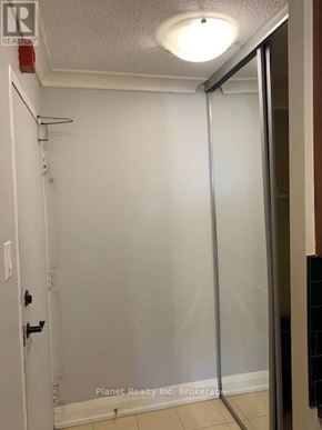 Guelph (Downtown) condo for rent - A white bathroom with a glass shower door and a white door.