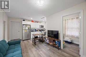 London East (East F) multi-family for rent - A living room with a blue couch and a television.