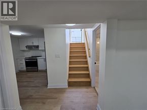 St. Catharines apartment for rent - A staircase leads up to a window in a white room.