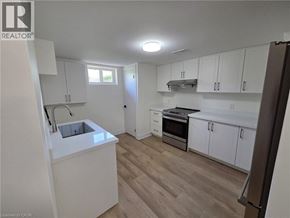 St. Catharines apartment for rent - A kitchen with white cabinets and a wooden floor.