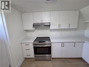 St. Catharines apartment for rent - A kitchen with white cabinets and a stainless steel range hood.